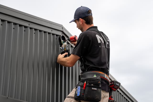 Nelson wiring an outdoor light on a new shed